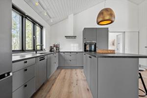 a kitchen with white cabinets and a wooden floor at HS018-Henne-Hennebysvej-8 in Henne Strand