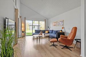 a living room with a blue couch and a table at HS018-Henne-Hennebysvej-8 in Henne Strand