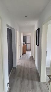 an empty hallway with white walls and wood floors at Ferienwohnung Am Palmberg in Gerolsheim
