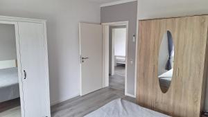 a bedroom with a wooden door and a mirror at Ferienwohnung Am Palmberg in Gerolsheim +1 photo