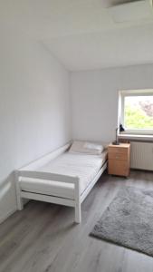 a white bed in a room with a window at Ferienwohnung Am Palmberg in Gerolsheim