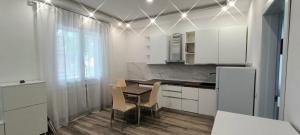 a kitchen with white cabinets and a table and chairs at Chez Romeo in Ravenna