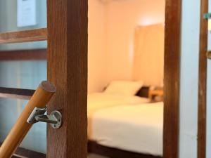 a room with two beds and a wooden door at ura San Jose ツインルーム in Okayama