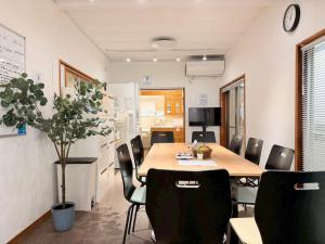 a room with a table and chairs and a kitchen at ura San Jose ツインルーム in Okayama