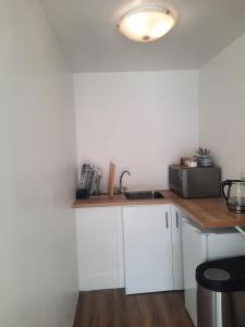 a kitchen with white cabinets and a counter top at Berg and Dal in Paarl