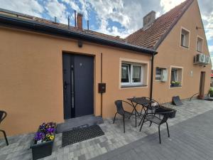 a patio with a table and chairs next to a house at Dom przy świerku in Elblag