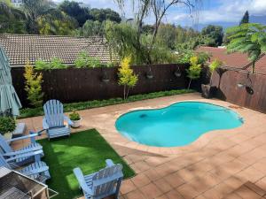 a small swimming pool in a yard with two chairs at Berg and Dal in Paarl +4 photos