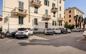 a parking lot with cars parked in front of a building at Domi Home in La Spezia