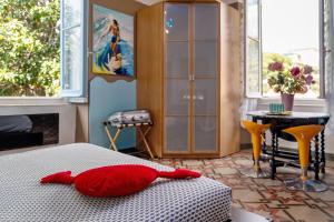 a bedroom with a bed with a red pillow on it at Sentieri in Levanto