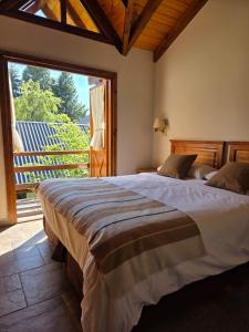 a bedroom with a large bed with a large window at Ayelen Andina in Esquel +170 photos