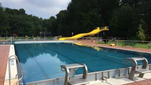 a swimming pool with a yellow slide in a park at Ferienwohnung in Ivenack, DG in Ivenack