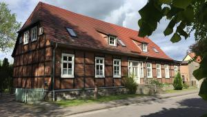 an old wooden building with a red roof at Ferienwohnung in Ivenack, DG in Ivenack