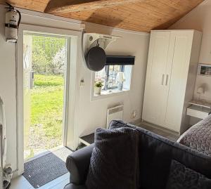 a room with a couch and a bed and a window at Stubbhuggets Lillstuga in Trosa