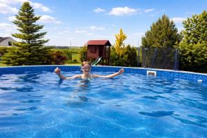 a young child swimming in a swimming pool at Pension U Babi in Chrášťany
