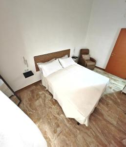 a bedroom with a large white bed and a chair at Zio Achille in Gallipoli