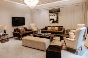 a living room with couches and chairs and a tv at Summer Villa in Lahore