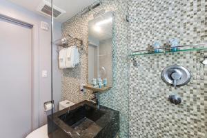 a bathroom with a shower with a black sink at Alamo Hotel in Miami Beach +32 photos