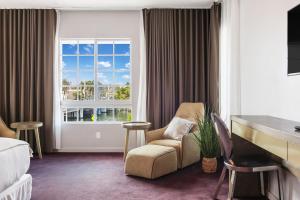 a hotel room with a chair and a window at Alamo Hotel in Miami Beach