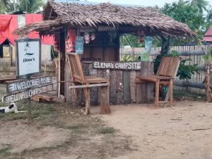 a shack with two chairs in front of it at Elenas Campsite in San Vicente
