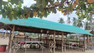 a group of tables and chairs under a blue roof at Elenas Campsite in San Vicente