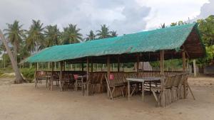 a restaurant with tables and chairs and a blue roof at Elenas Campsite in San Vicente