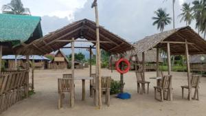 a group of tables and chairs under umbrellas on the beach at Elenas Campsite in San Vicente
