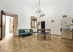 a living room with a blue couch and a table at Zio Achille in Gallipoli +8 photos