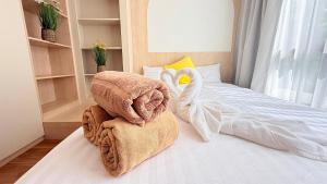 a bedroom with two swans towels on a bed at Fantasea Condo Kamala 1bdr in Kamala Beach