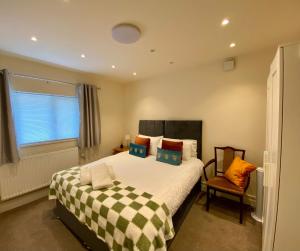 a bedroom with a bed and a window and a chair at Modern 2 bed ground floor flat in Watford