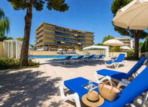 a pool with blue lounge chairs and a building at Villa Bono Romantic Suite & Private Jacuzzi in Saint-Laurent-du-Var