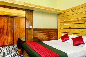 a bedroom with a bed with red pillows at RAGAM RESORT in Alleppey