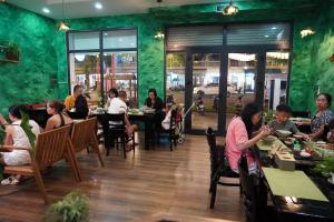 a group of people sitting at tables in a restaurant at Lam Stay Grand World Phu Quoc in Phú Quốc