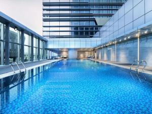 a large swimming pool inside of a building at Pullman Shenzhen North in Shenzhen