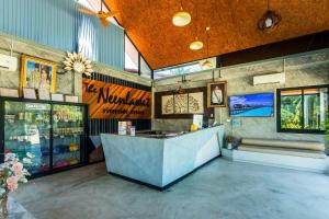 a restaurant with a counter in the middle of a room at Neenlawat Riverside in Suratthani