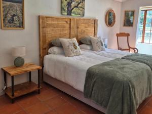 a bedroom with a large bed with a wooden headboard at River Glen Farm in Winterton
