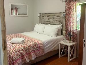 a bedroom with a bed with a wooden headboard at River Glen Farm in Winterton +10 photos