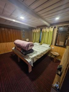 a bedroom with a bed in a room with green curtains at The magic meadows in Kulu