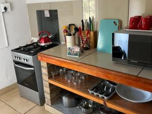 a kitchen counter with a stove and a microwave at River Glen Farm in Winterton