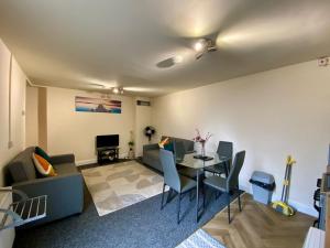 a living room with a couch and a table at Modern 2 bed ground floor flat in Watford