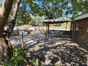 a patio with a table and chairs under a tree at River Glen Farm in Winterton