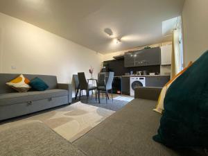 a living room with a couch and a table at Modern 2 bed ground floor flat in Watford +9 photos