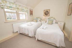 zwei Einzelbetten in einem Zimmer mit Fenster in der Unterkunft Carlton Towers Estate - Stapleton Rooms & Parkgate Cottages in Carlton