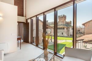 a living room with large windows and a view of a castle at Suite della Torre in Cavernago +12 photos