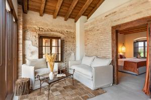 a living room with white chairs and a brick wall at Suite della Torre in Cavernago