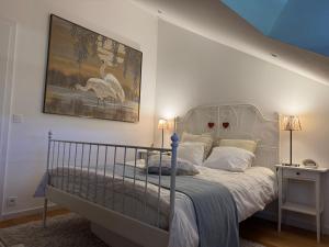 ein Schlafzimmer mit einem Bett und einem Gemälde an der Wand in der Unterkunft Chez Arli in Attert