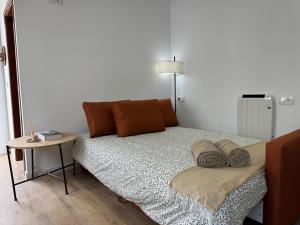 a bed with pillows and a table in a room at LaJoya Zuheros Suite in Zuheros