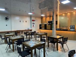 a restaurant with tables and chairs and a kitchen at Raludi Hotel in Barcarena +7 photos