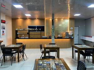 a restaurant with tables and chairs and a counter at Raludi Hotel in Barcarena