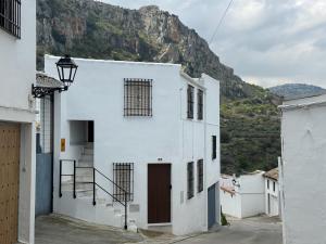 a white building with a mountain in the background at LaJoya Zuheros Suite in Zuheros