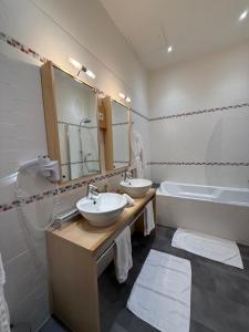 a bathroom with two sinks and a bath tub at Les chambres du Domaine Rollan de By in Bégadan +16 photos